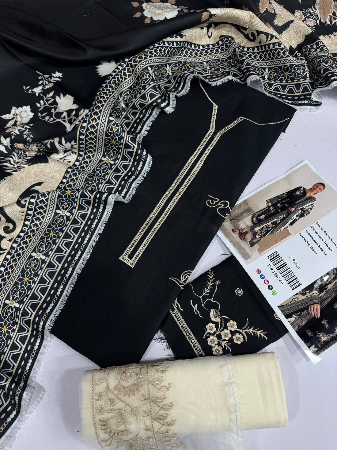 A three-piece women's ethnic wear set by Zeen, featuring a black and beige embroidered kurta, a matching embroidered trouser, and sleeves, shown on a model against a neutral studio backdrop.