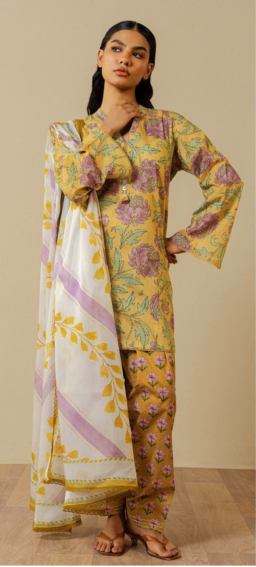 A model wearing a printed three-piece traditional outfit from ZARA SHAHJAHAN, displayed on a split background with product details, care instructions, and a QR code.