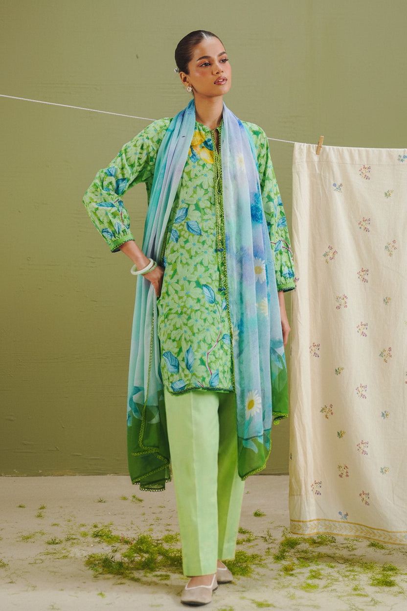A catalog page for COCO by Liza Shakirman Prints, featuring a model wearing a green and blue printed traditional outfit with a matching dupatta on the left, and product details on the right including style name KAEL-7B, package contents, and care instructions.