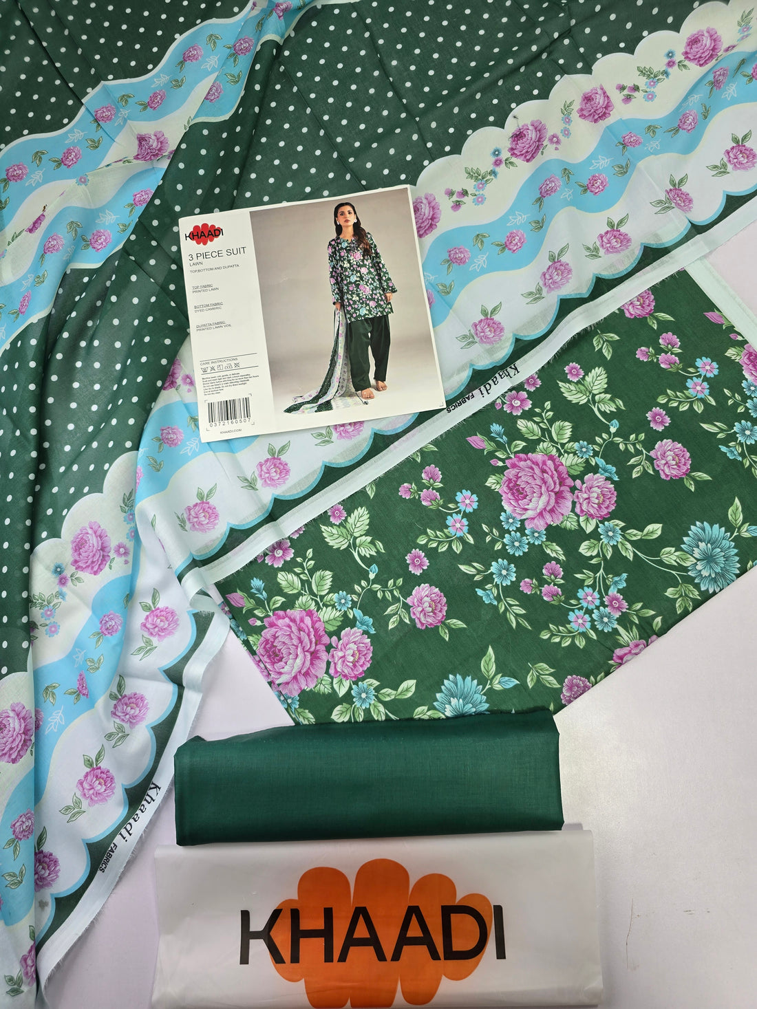 Khaadi 3-piece suit for women in green lawn fabric, featuring a printed long kurta, solid green pants, and a matching printed dupatta, shown on a model against a light gray background with product details on the left.