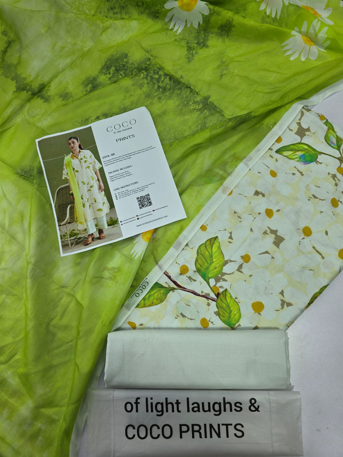 A fashion catalog page showing a woman modeling a COCO by Iqra Shakirman print outfit, with text details about the Zoya-BB dress on the right side.