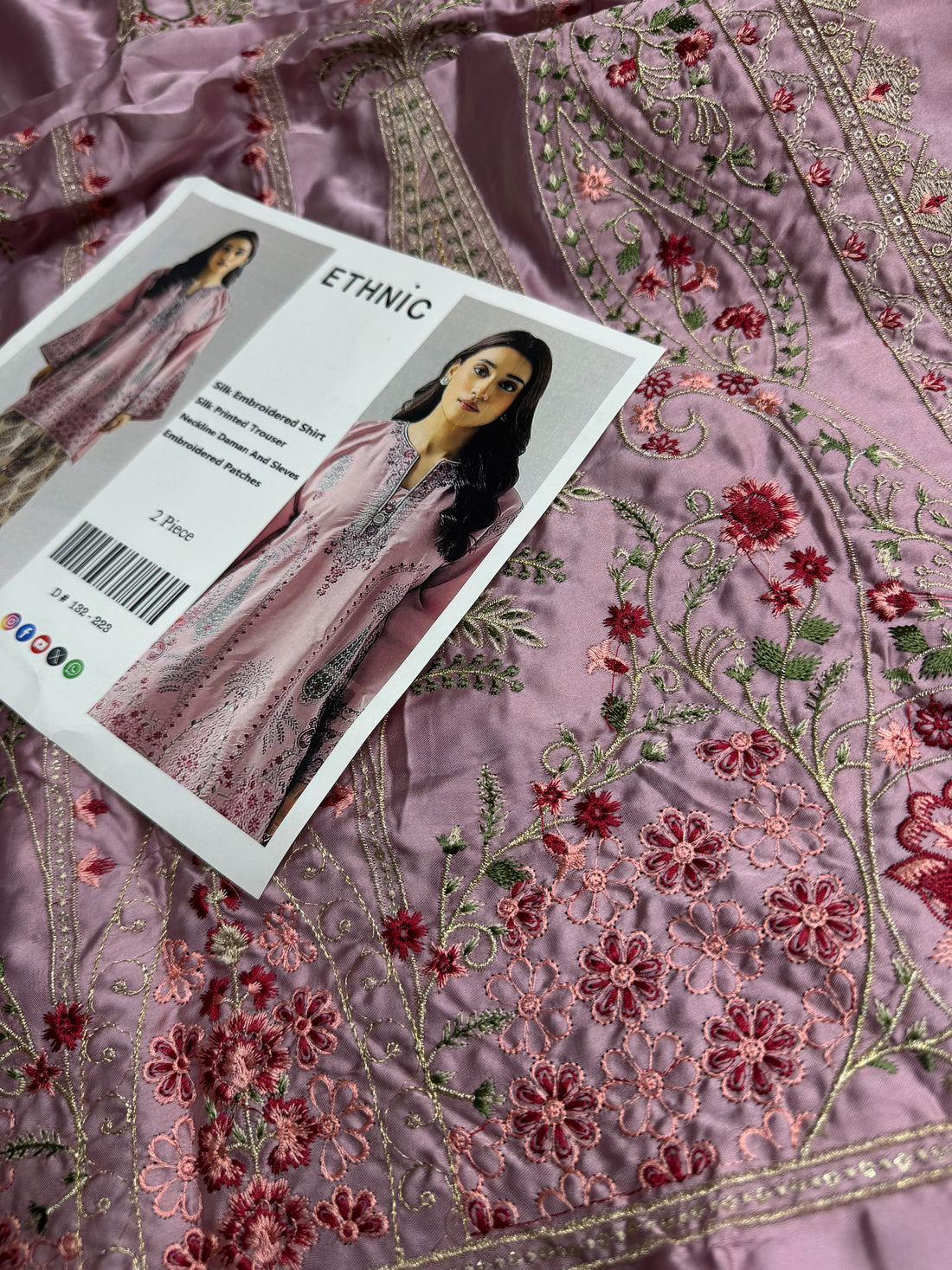 A two-piece women's ethnic outfit shown on a model against a light gray studio background, with close-up and full-body views. The set includes a dusty pink embroidered kurta and beige printed trousers.