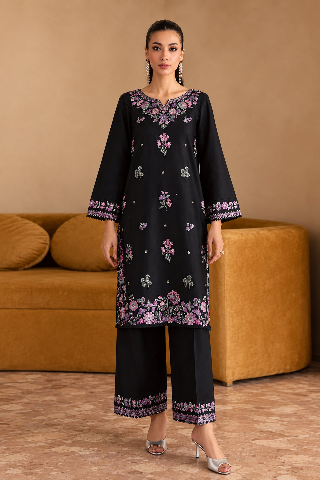 A woman models a black batik kurta and trouser set with pink and green floral embroidery, standing in front of a brown sofa. The text 'BATIK CODE 100014' is visible in the top right corner.
