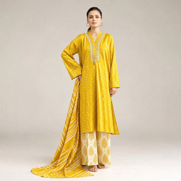 A woman modeling a yellow three-piece suit from Khaadi Lawn, featuring a printed kurta, matching printed shirt, and printed trouser, with a dupatta draped over her lap. The image is set against a light beige background with product details and an barcode printed on the left side.