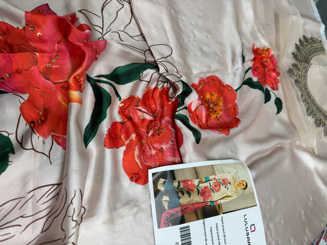 A model wears a cream-colored Lulusar digital print silk ethnic suit with large pink peony floral motifs, green leaves, and teal accents on the kurta, dupatta, and trousers. The image is a composite showing full-length and close-up views alongside product specifications.