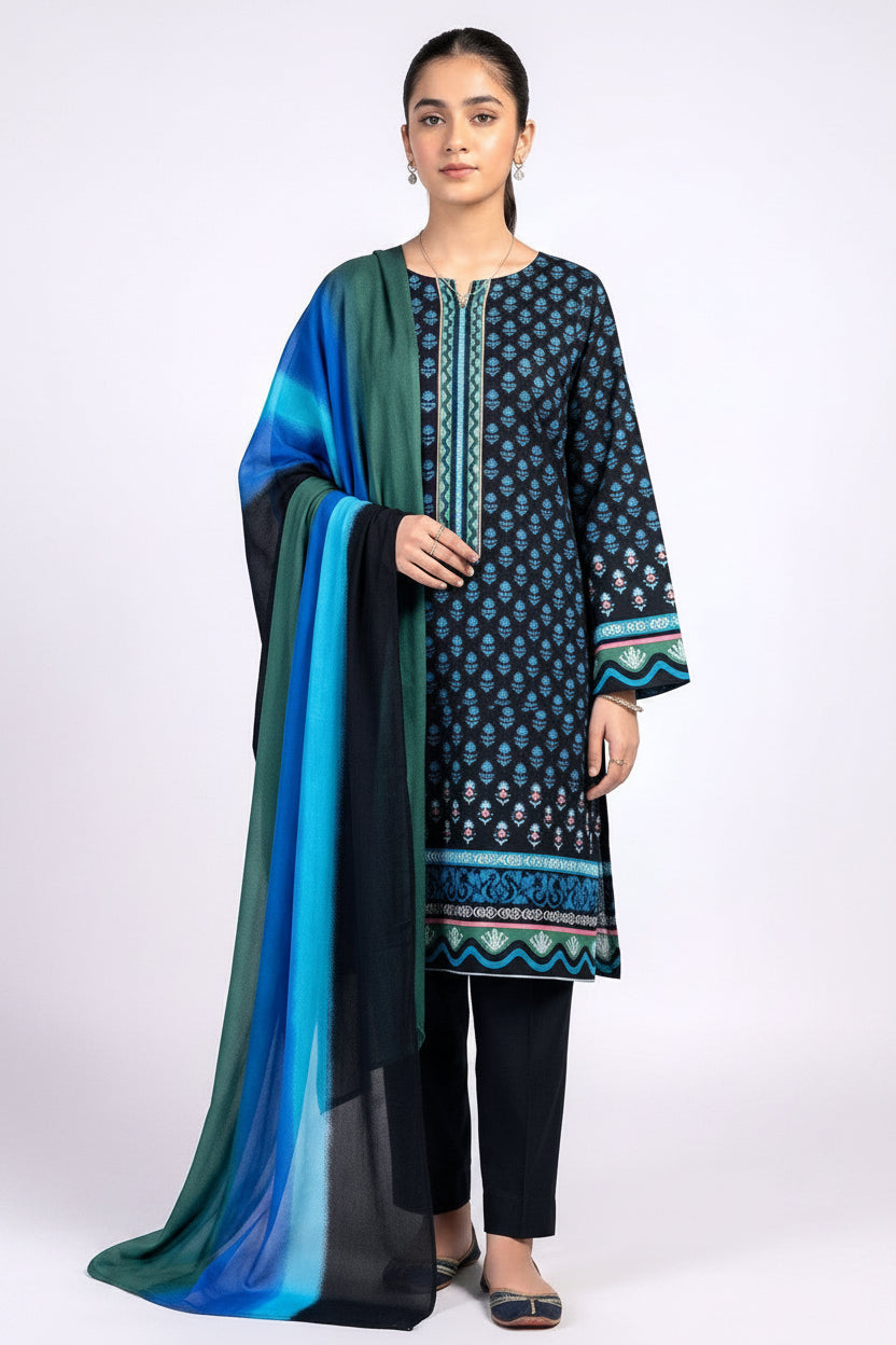 A model wears a three-piece printed lawn suit from Design Stock, featuring a blue and teal kurta with black and gold patterns, a matching printed shirt, and a dupatta. The image is a product information card with text details, a barcode, and care instructions on a white background.