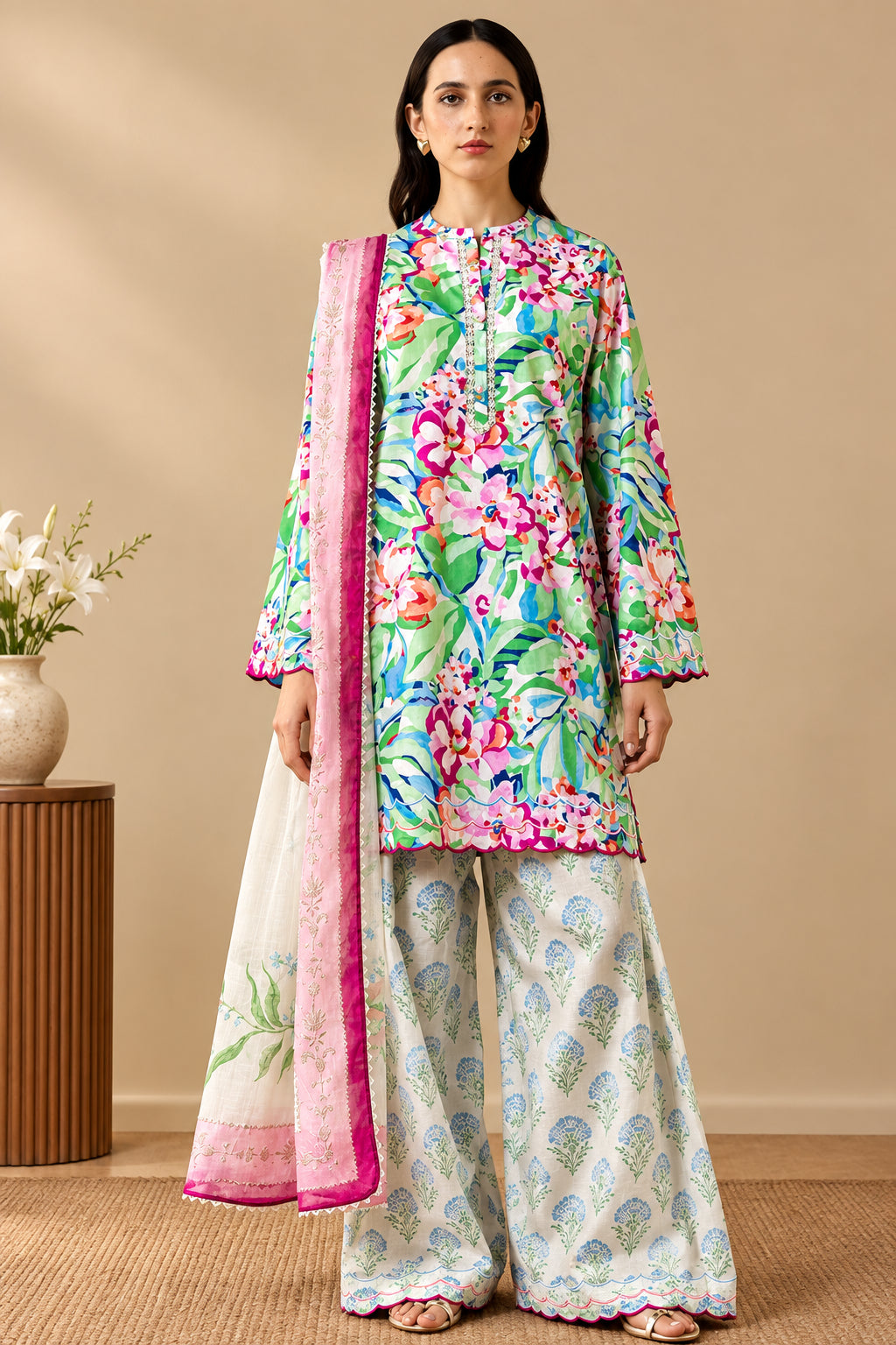 A model wearing a floral printed kurta and matching trousers with a pink border dupatta, shown on the left against a beige studio backdrop. The right side contains brand text reading 'COCO BY ZARA SHAHJAHAN PRINTS', product details for 'ELARIS-6A', package contents, care instructions, and a QR code.