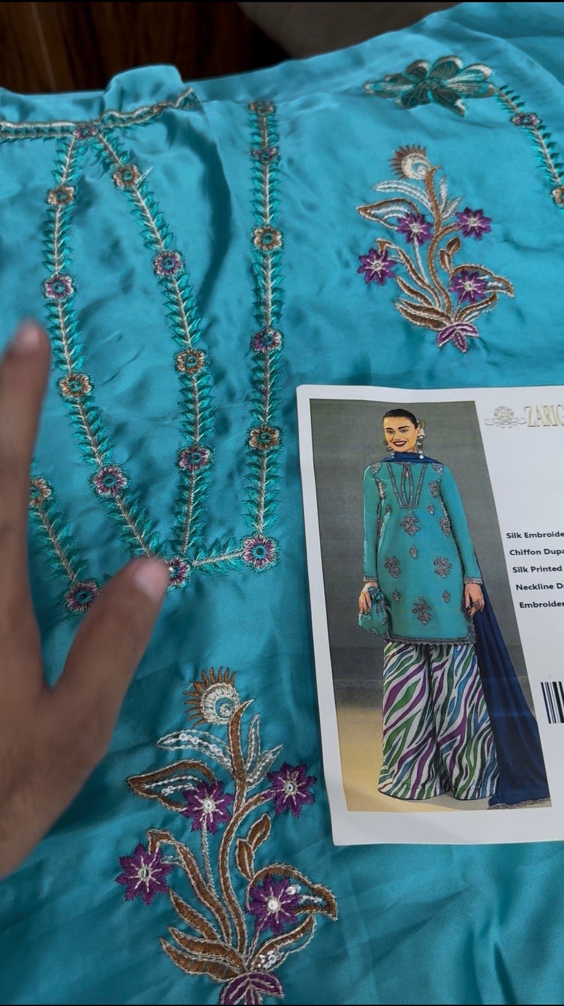 A 3-piece women's ethnic suit set by Zarichar, featuring a teal embroidered kurta, a striped chiffon dupatta, and a printed silk trouser. The image shows a model wearing the set from both front and back angles on a split gray and white background with product details listed in the center.