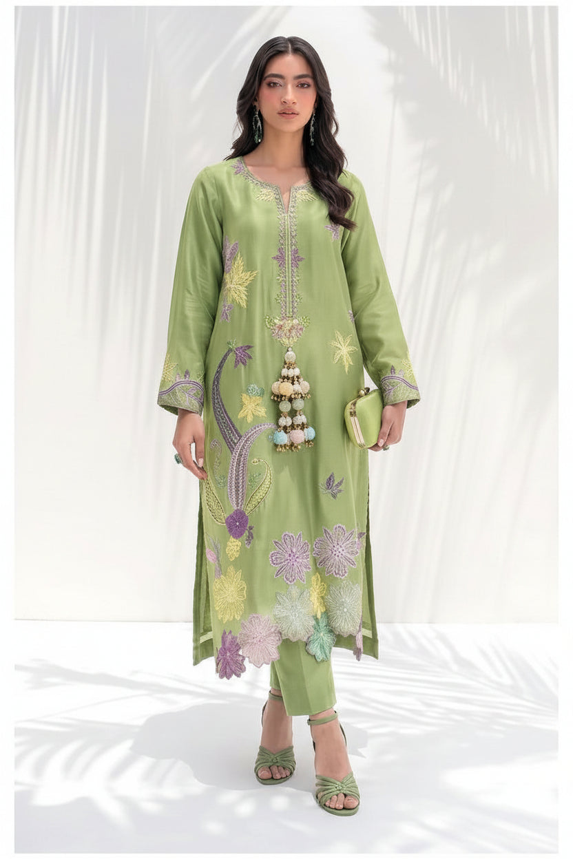 A woman models a light green silk two-piece kurta set with colorful floral embroidery, shown next to product specifications and care instructions on a white background. The brand logo 'Sidrah & Sarah' is visible in the top right.