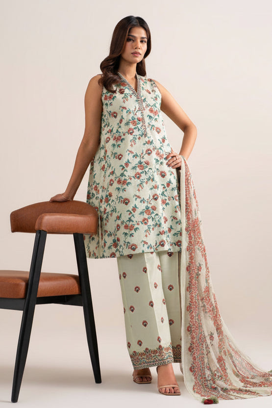 A model wears a three-piece printed khaddar suit from Sapphire, featuring a sleeveless kurta, matching trousers, and a dupatta. The set has a cream base with a vibrant multicolor floral print.