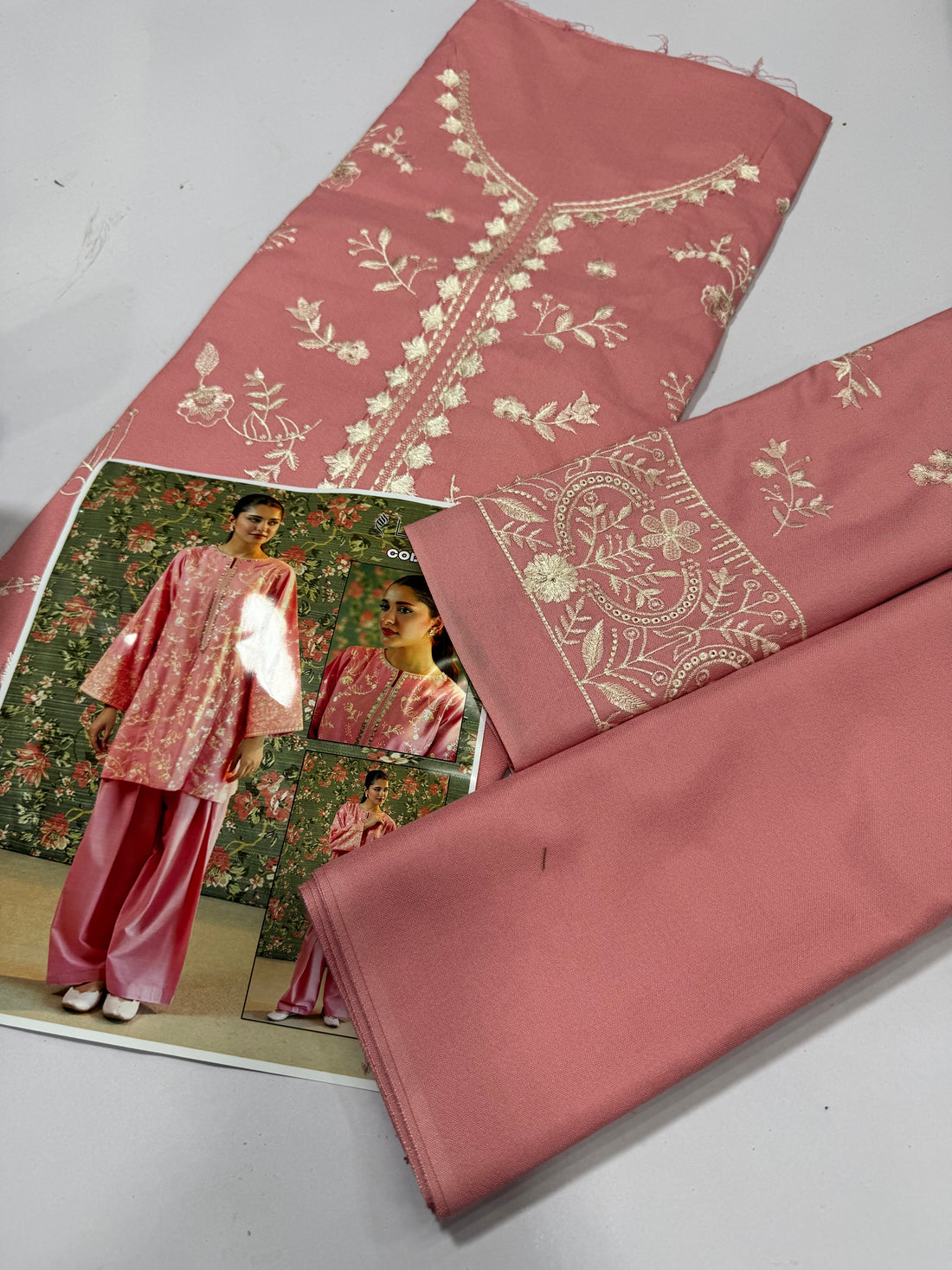 A woman models a pink traditional outfit with a floral patterned kurta and matching wide-leg pants. The image includes a main full-body view, a close-up inset of the upper body, and a smaller full-body inset, all against a floral wallpaper background.