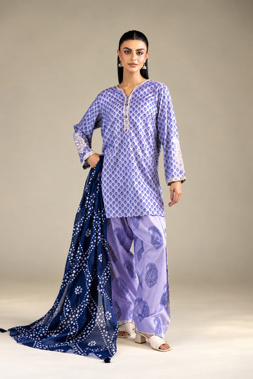 A model wearing a Khaadi 3-piece suit in lavender and navy blue, featuring a printed kurta, matching trousers, and a printed dupatta, set against a neutral studio background with product details on the left.