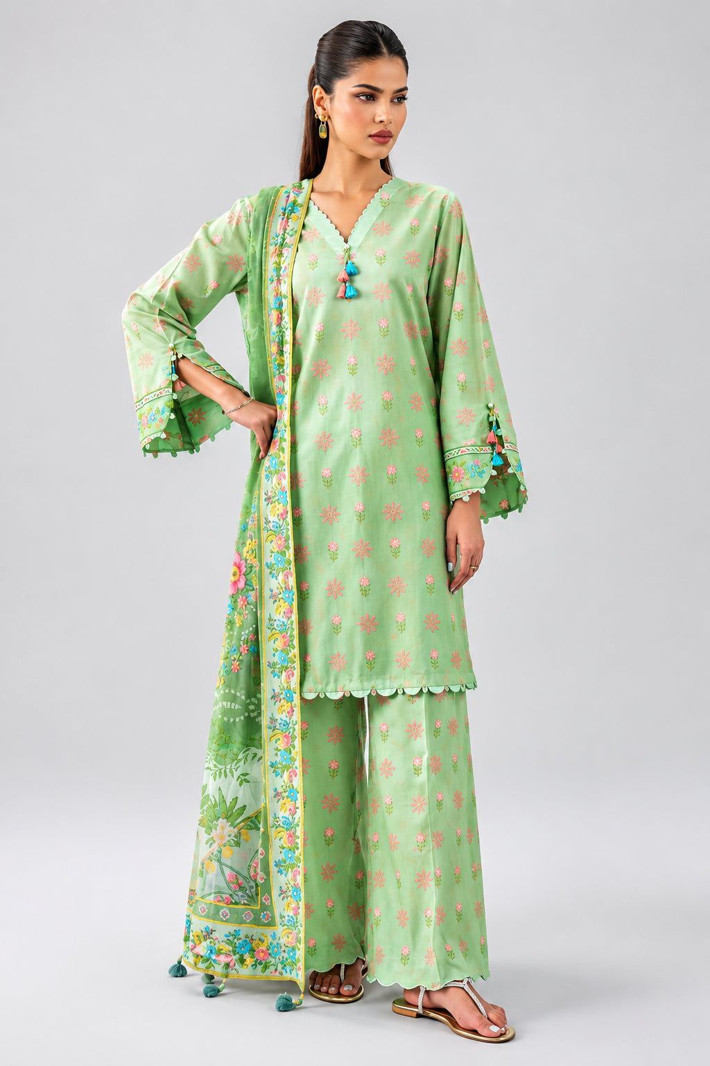 A model wearing a three-piece light green printed kurta set by Nishat Unstitched, shown on a clean white background with product details and a QR code printed on the left side of the page.