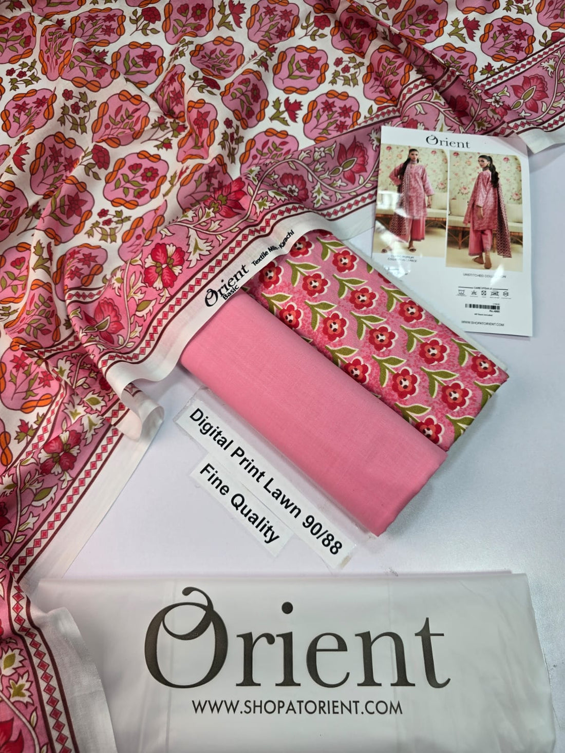 A catalog page for an unstitched collection from the brand Orient, showing two side-by-side photos of a model wearing a pink printed kurta and matching pants. The page includes product details, care instructions, and a barcode.